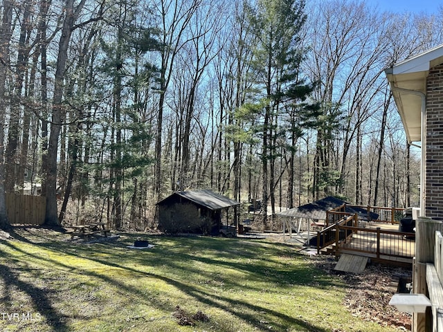 view of yard featuring an outdoor structure and a deck