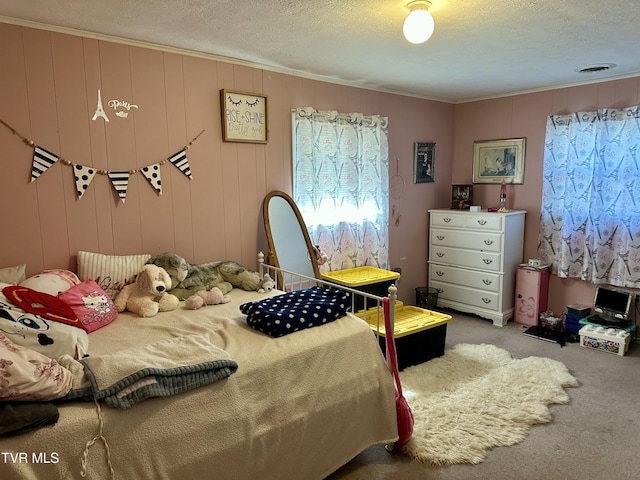 bedroom featuring carpet floors, visible vents, crown molding, and a textured ceiling