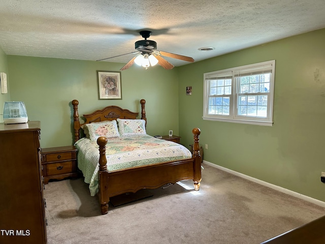 carpeted bedroom featuring a textured ceiling, a ceiling fan, visible vents, and baseboards