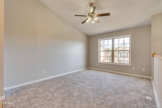 unfurnished room featuring vaulted ceiling, a textured ceiling, carpet flooring, and a ceiling fan