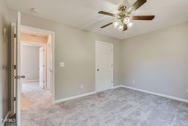 unfurnished bedroom with carpet, baseboards, ceiling fan, and a textured ceiling