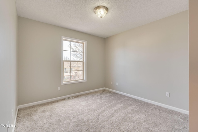 spare room featuring carpet flooring, visible vents, and baseboards