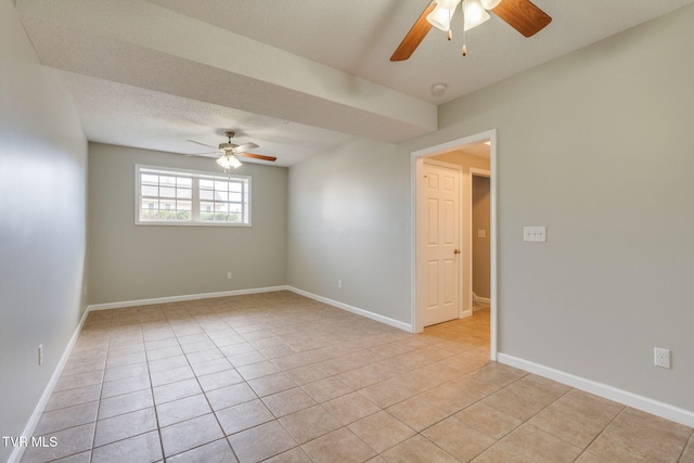 spare room with light tile patterned floors, ceiling fan, a textured ceiling, and baseboards