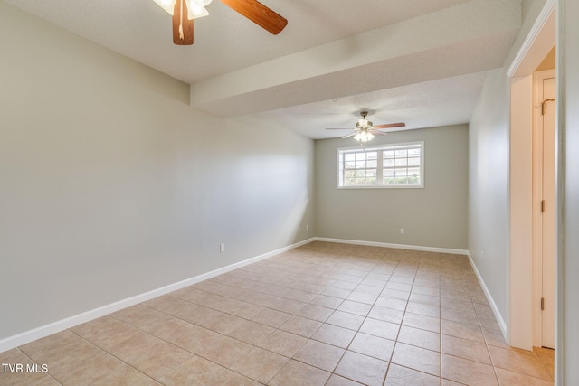 empty room with light tile patterned floors, ceiling fan, a textured ceiling, and baseboards