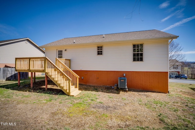 rear view of property featuring a deck, central AC, fence, and stairway