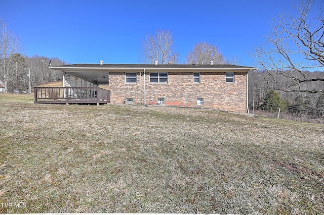 rear view of house with a yard, brick siding, and a wooden deck