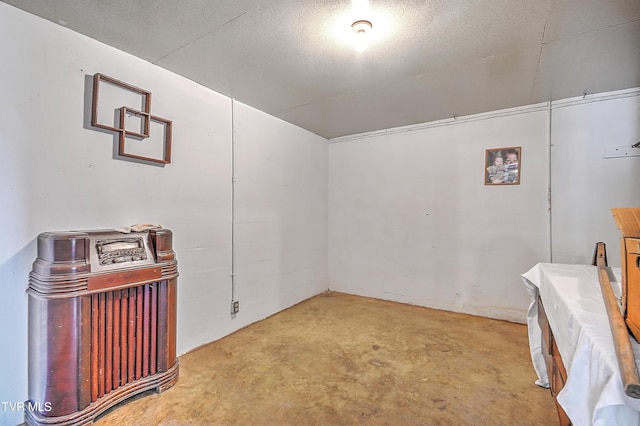 empty room featuring a textured ceiling and unfinished concrete floors