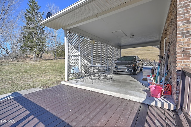 wooden deck featuring an attached carport and a lawn