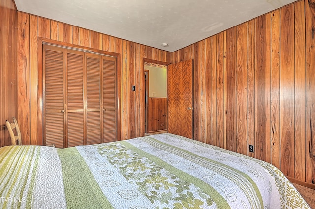 bedroom with a closet and wooden walls