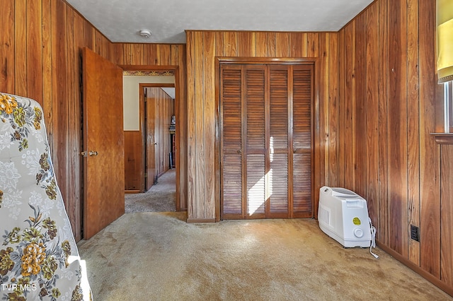 spare room with carpet and wooden walls