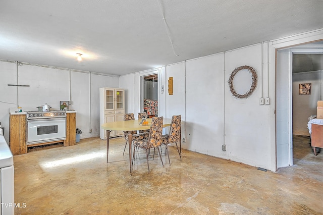 dining space with concrete flooring and a textured ceiling