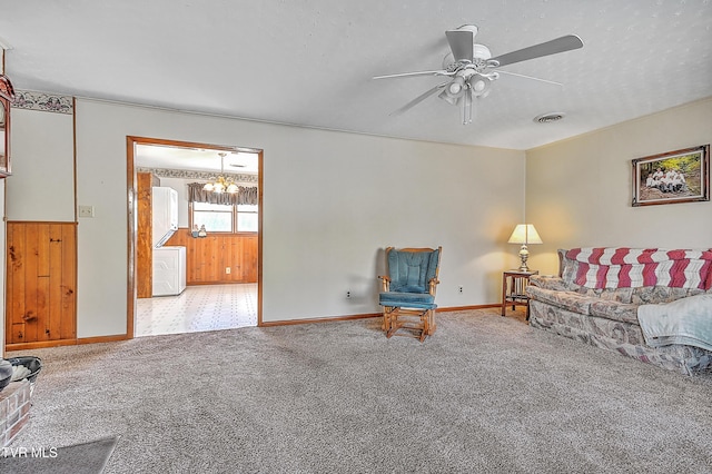 living room featuring visible vents, washer / clothes dryer, a textured ceiling, carpet floors, and ceiling fan with notable chandelier