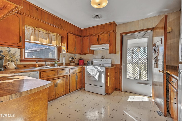 kitchen featuring under cabinet range hood, a sink, visible vents, brown cabinetry, and white electric range oven