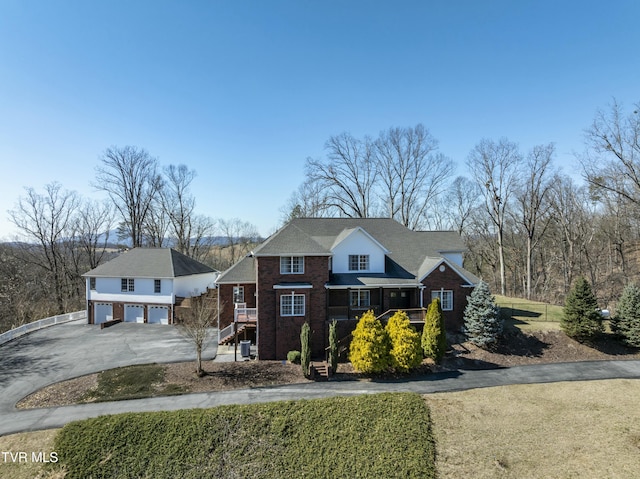 view of front of house featuring brick siding, driveway, and a garage