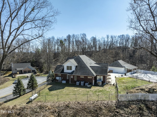 rear view of property featuring a fenced front yard, brick siding, and a yard