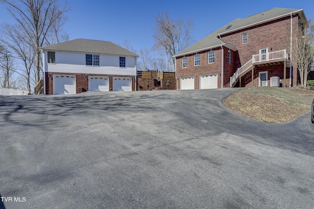 view of property exterior featuring stairway, an attached garage, and brick siding