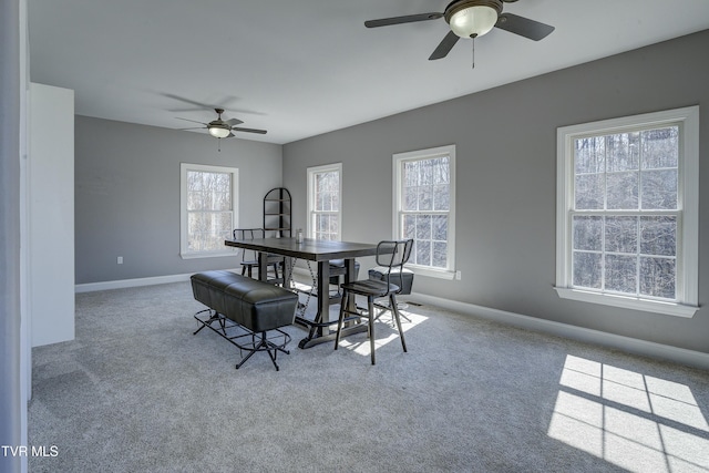 carpeted dining room with baseboards and a ceiling fan