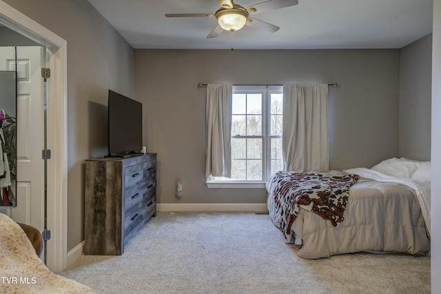 bedroom featuring light colored carpet, a ceiling fan, and baseboards