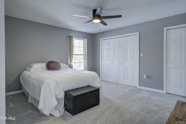 bedroom with a ceiling fan, a textured ceiling, a closet, carpet, and baseboards