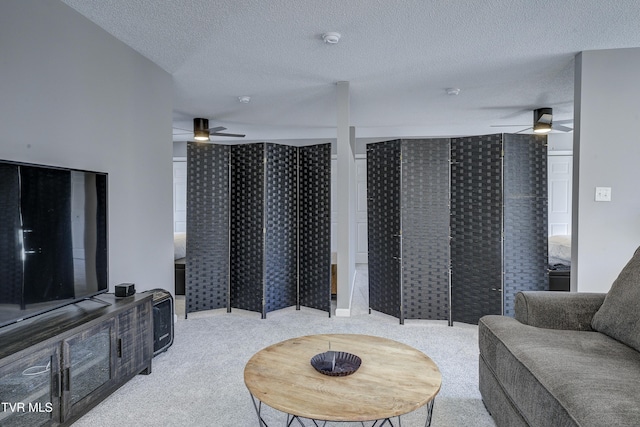 carpeted living room featuring a textured ceiling and ceiling fan