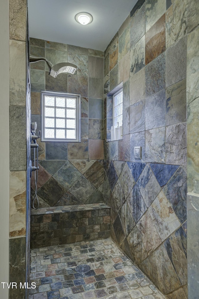 bathroom featuring a wealth of natural light and a tile shower