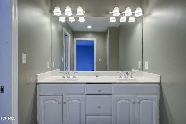 full bathroom with a sink and double vanity