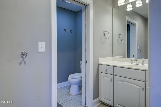 bathroom featuring toilet, vanity, and baseboards