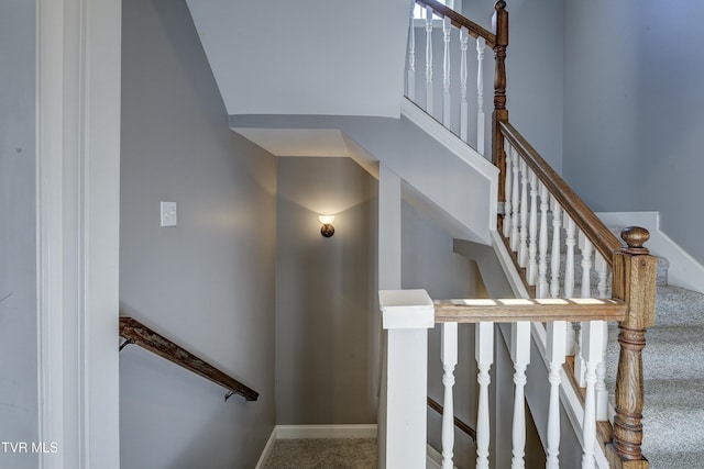 staircase featuring baseboards and carpet