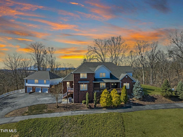 view of front of property featuring a garage, a front lawn, brick siding, and driveway