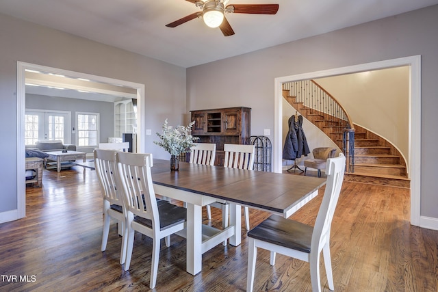 dining room featuring stairway, baseboards, wood finished floors, and a ceiling fan