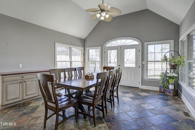 dining area featuring visible vents, high vaulted ceiling, a ceiling fan, stone tile flooring, and baseboards