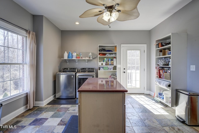 kitchen with open shelves, baseboards, independent washer and dryer, and stone tile flooring