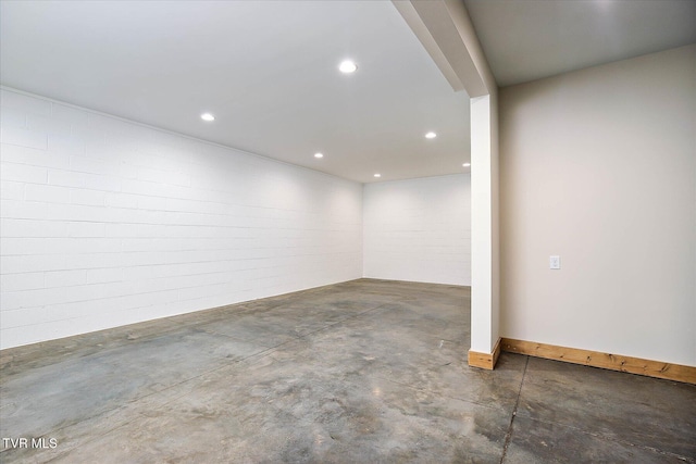 below grade area with recessed lighting and brick wall