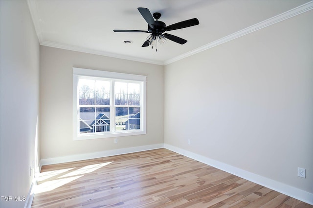 spare room featuring ceiling fan, visible vents, baseboards, ornamental molding, and light wood-type flooring