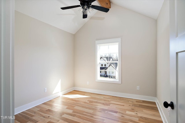 spare room with lofted ceiling with beams, ceiling fan, wood finished floors, and baseboards