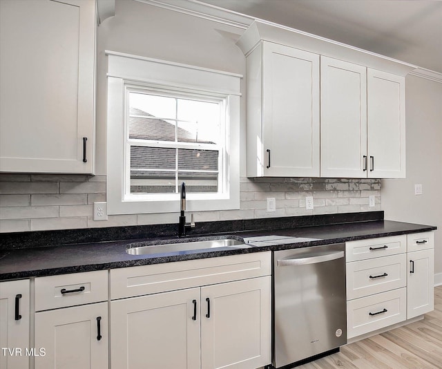 kitchen with dishwasher, a sink, white cabinets, and decorative backsplash