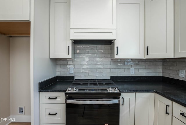 kitchen with dark countertops, gas stove, backsplash, and white cabinetry