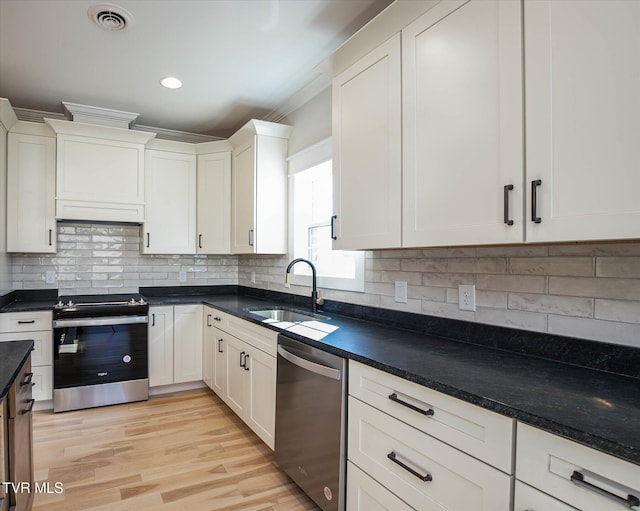 kitchen featuring light wood-style flooring, a sink, visible vents, ornamental molding, and appliances with stainless steel finishes