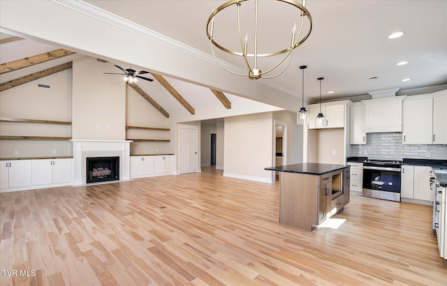 kitchen with a fireplace, white cabinets, appliances with stainless steel finishes, dark countertops, and crown molding