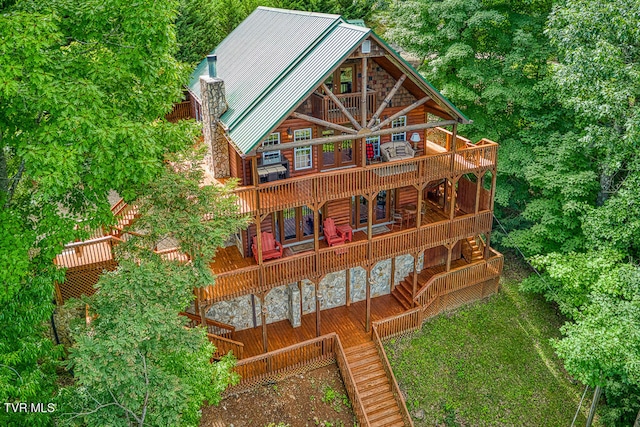 exterior space featuring a deck, a chimney, and metal roof