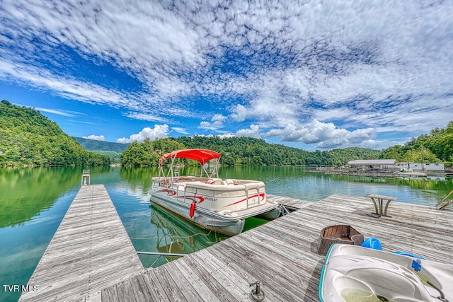 view of dock featuring a forest view and a water view