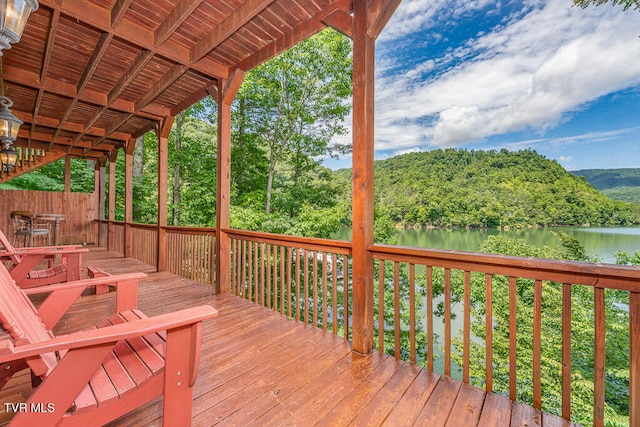 wooden terrace with a water view and a wooded view