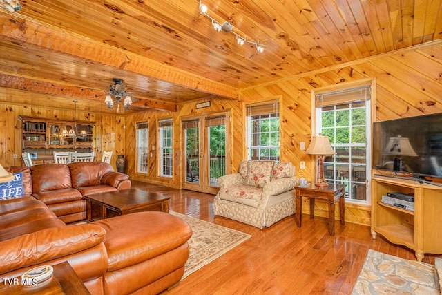 living area with wooden ceiling, rail lighting, wooden walls, and hardwood / wood-style flooring