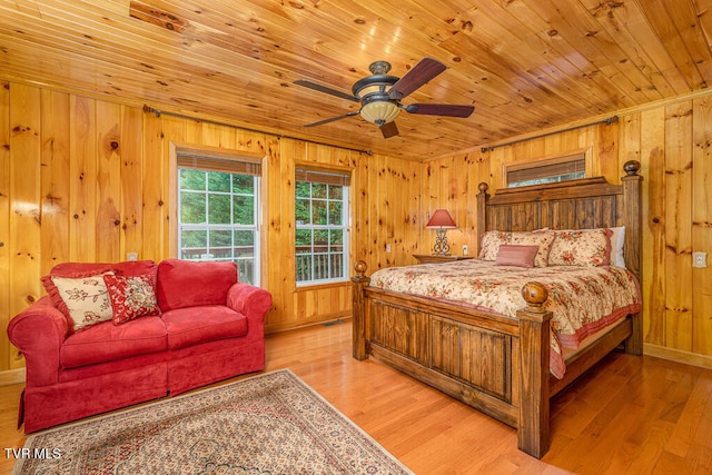 bedroom with ceiling fan, wood walls, light wood-type flooring, and wood ceiling