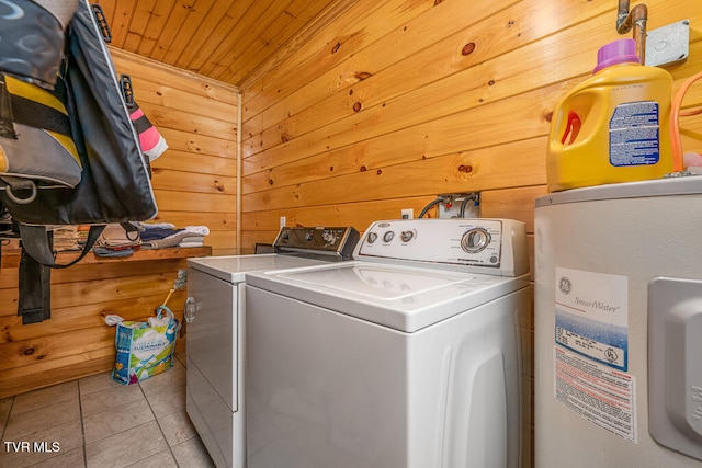 clothes washing area featuring washer and clothes dryer, wood ceiling, light tile patterned flooring, wood walls, and laundry area