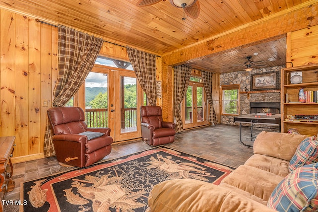 living area featuring ceiling fan, french doors, wooden ceiling, and stone tile floors