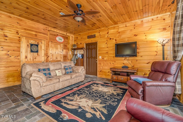 living area featuring wooden ceiling, wooden walls, and stone tile floors