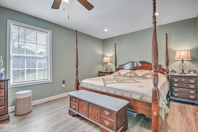 bedroom featuring light wood-style floors, multiple windows, and baseboards