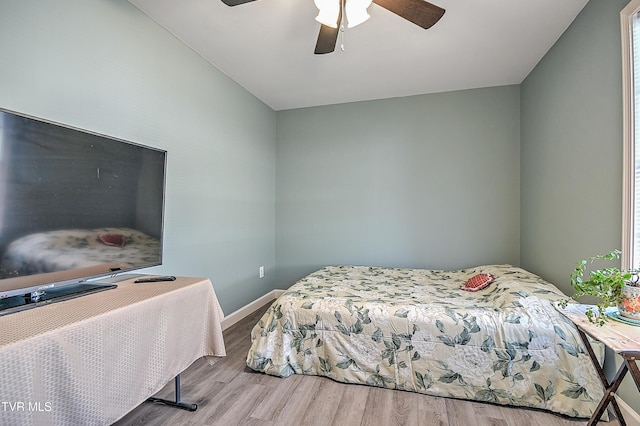 bedroom featuring a ceiling fan, baseboards, and wood finished floors