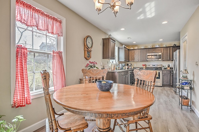 dining space with baseboards, light wood-style floors, recessed lighting, and a notable chandelier